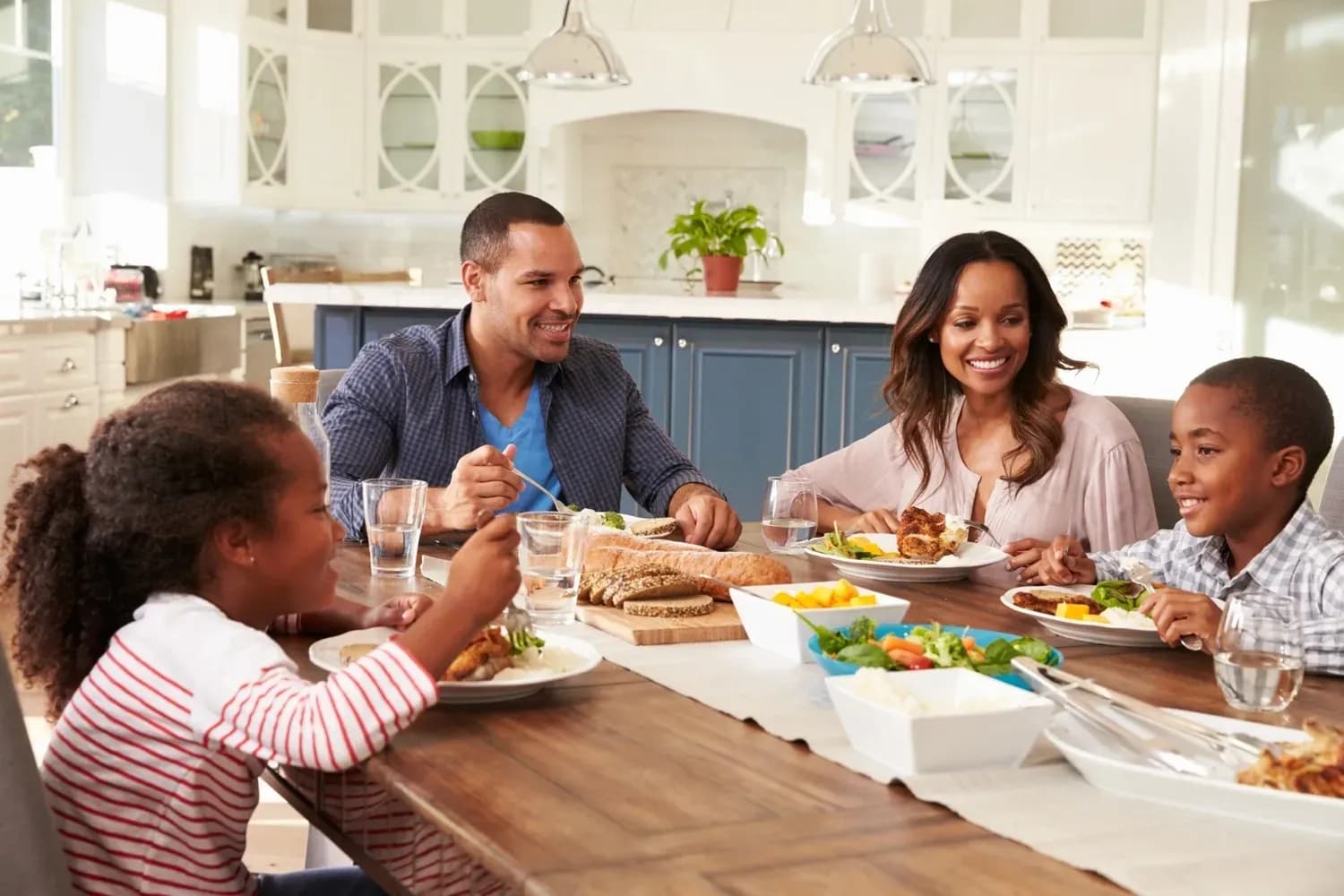 A family gathered around a wooden kitchen table in warm evening light, sharing a meal and heartfelt conversation that reflects connection and belonging.